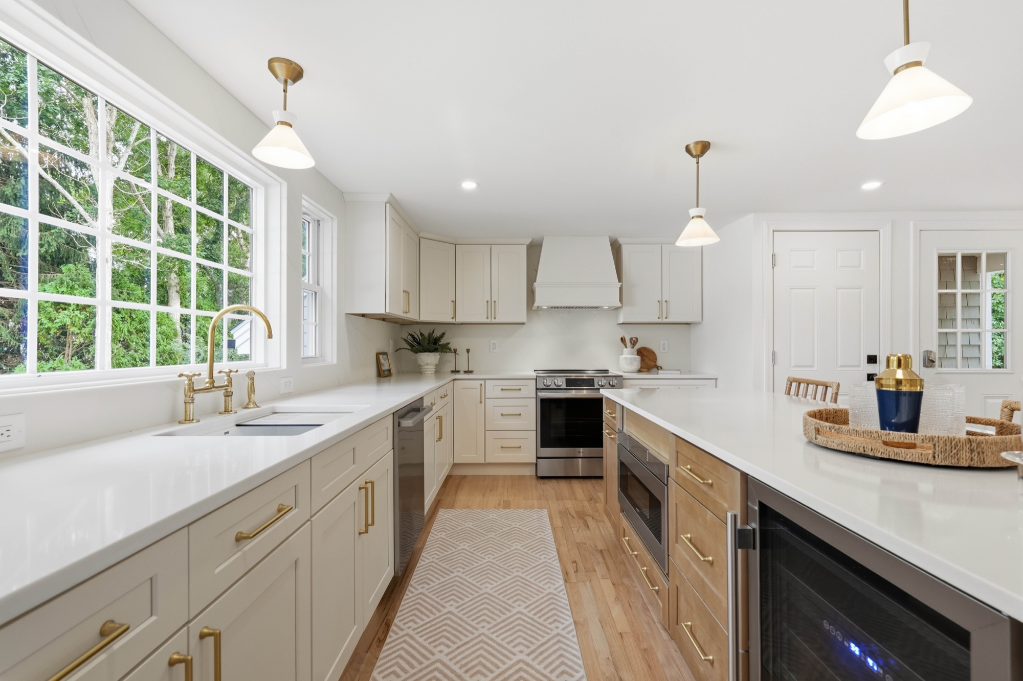 Bright renovated kitchen with quartz counters and brass fixtures