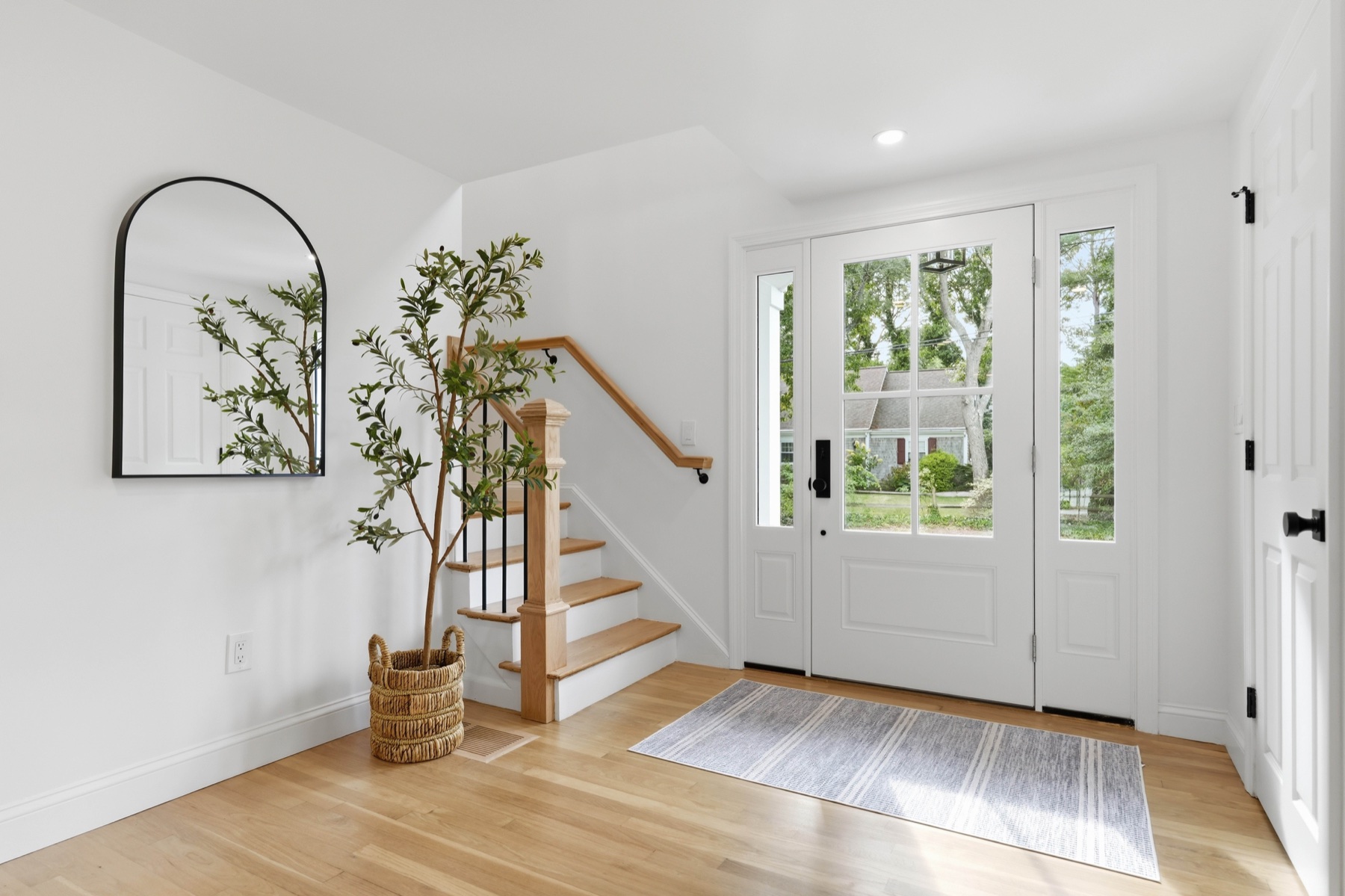Bright entry hall with natural wood staircase