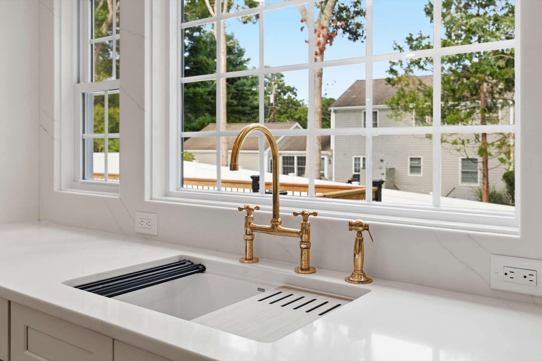 Unlacquered brass bridge faucet at the kitchen window